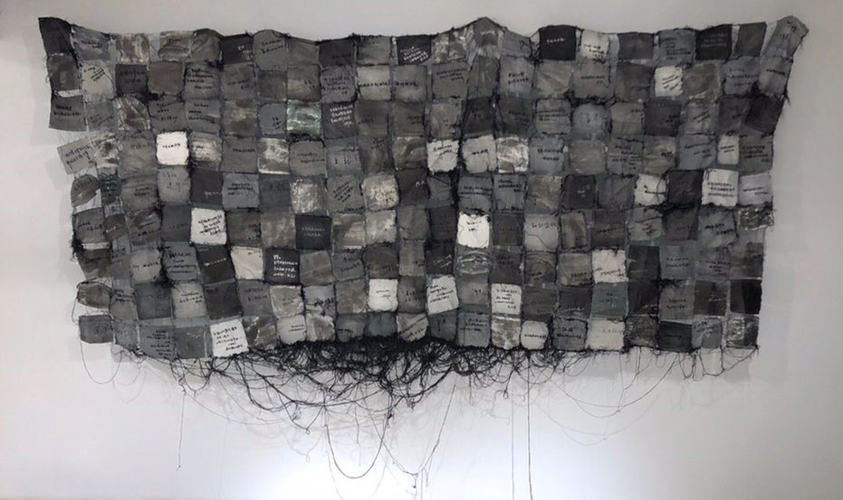 Art Installation of 365 possible ways to escape, each one written on a black square and sew together with black thread