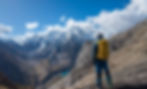 David (Co-Founder) standing with his back turned to the camera, in front of an impressive snow capped mountain ridge