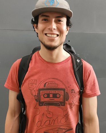 A portrait image of Daniel, an NXS Guide, wearing a red shirt, black backpack, and grey hat