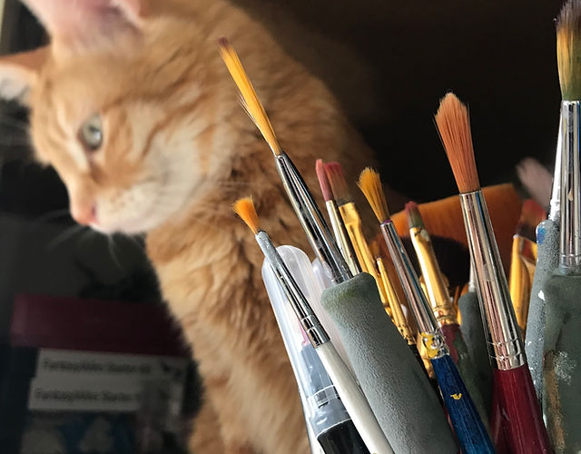 Mignon petit chat roux entouré de pinceau contemplant la beauté des tableaux mural