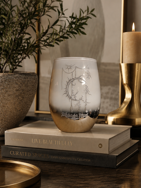 Luxury soy candle by Cedar Cove Candle Company displayed in a dark architectural interior featuring warm ambient lighting, sculptural decor, reflective metallic vessel design, and atmospheric luxury styling for interior designers, boutique hospitality spaces, artistic homes, and elevated modern interiors. 