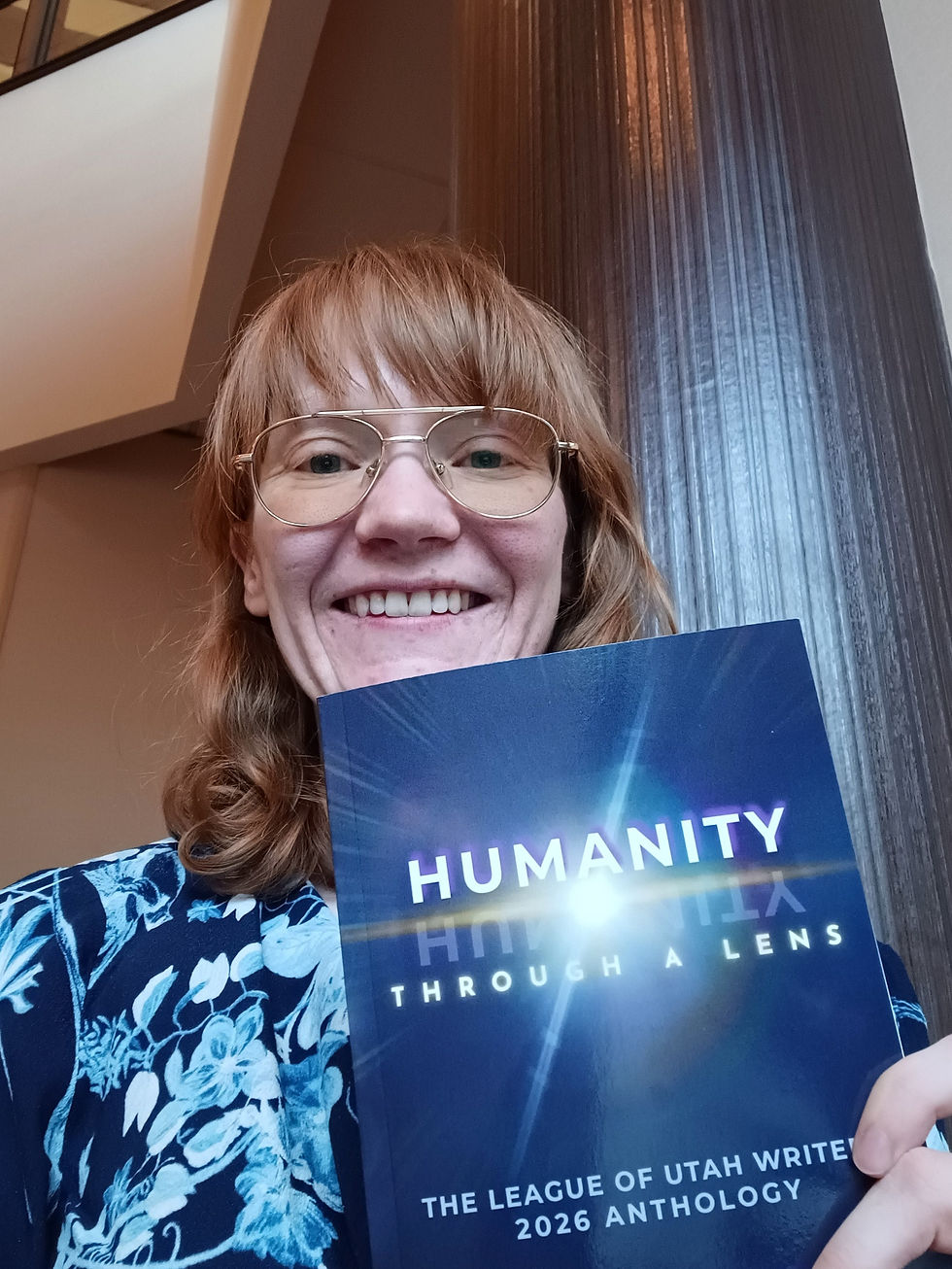 Dark fantasy author holds book titled Humanity Through a Lens that has her newest short story published inside. The story discusses healing and forgiveness in trauma aka finding the light in the dark