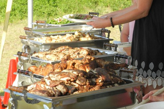 Beautifully arranged Picnic Master catering dishes on a buffet table as a guest serves themselves.
