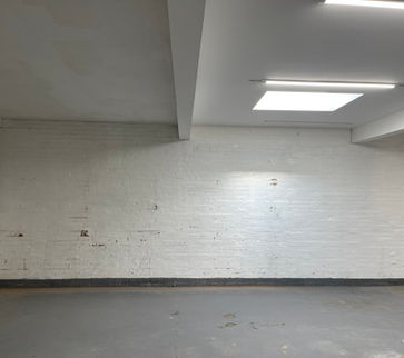 empty run down room with white wall and grey floor