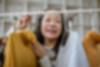 Senior woman looking at clothing on a rack and smiling