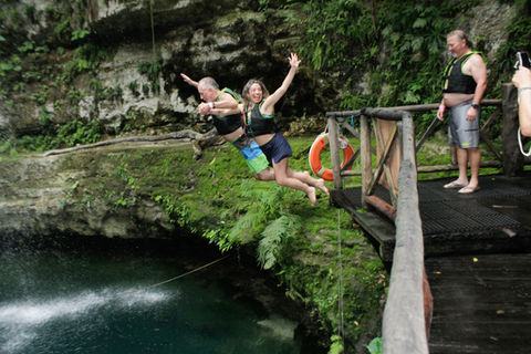 2 people jumping from platform at Saamal Cenote on a guided motorcycle tour on a Harley-Davidson