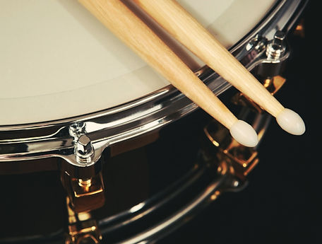 two drum sticks on a snare drum in a music studio