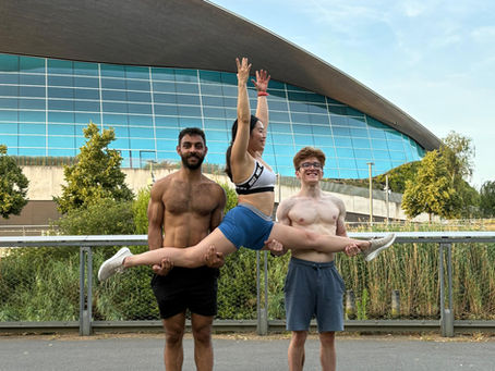 A gymnast doing a split on 2 acro bases 