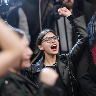 Ani Akhmeteli participe à une manifestation à Tbilissi, Géorgie. Elle est entourée de manifestant·es tenant des pancartes et drapeaux, exprimant leur opposition au Rêve géorgien et leur soutien aux libertés démocratiques.