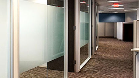 Hallway with glass-front offices.