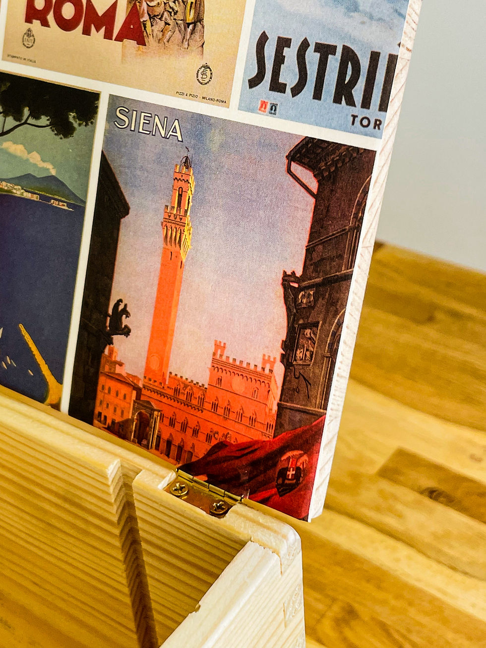 Miniaturbild: Siena Poster of a tower and buildings with text, wooden stand display.