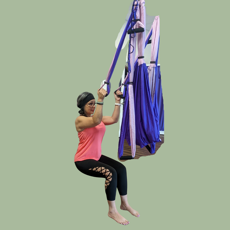 Steph wearing pink tank top and black leggings performing a 90/90 squat using the yoga trapeze