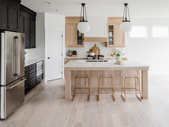 Modern kitchen with wood island, black cabinets, and stainless steel fridge