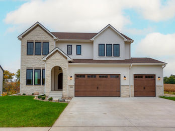 Large white and stone house with three-car garage