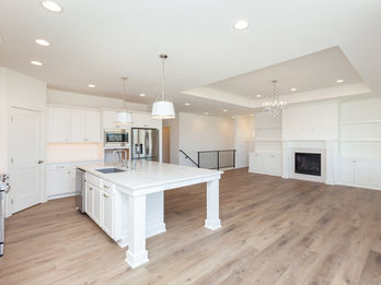 Modern white kitchen and open living room with fireplace