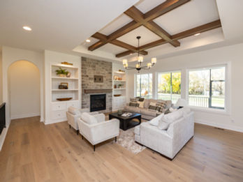 Spacious living room with stone fireplace, wood beam ceiling
