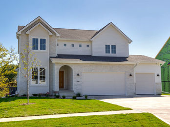 New build house with light facade and two-car garage