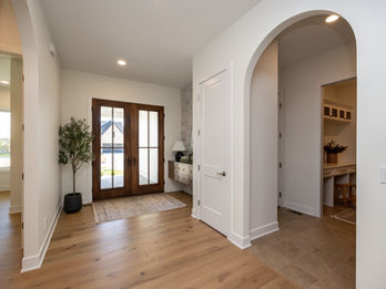 Bright entryway with wood floors and arched hallway