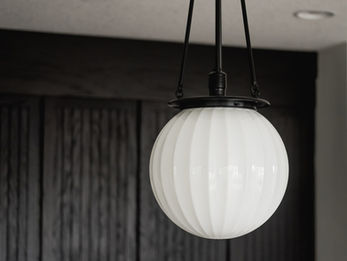 Modern globe pendant light over dark cabinets