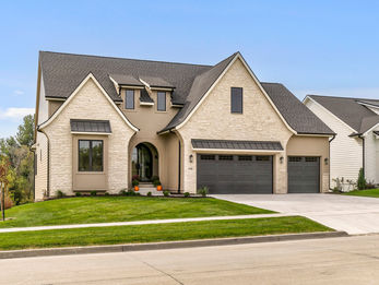 Modern house with light facade, dark roof, and two garages
