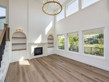 Bright living room with fireplace, built-in shelves, and large windows