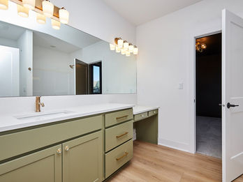 Modern bathroom with green vanity and gold fixtures