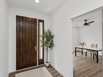 Modern entryway with dark wood door and dining area