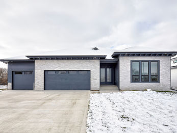 Modern grey home with two garages and snow