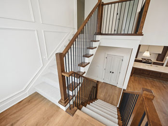 Modern staircase with wood railings and white walls