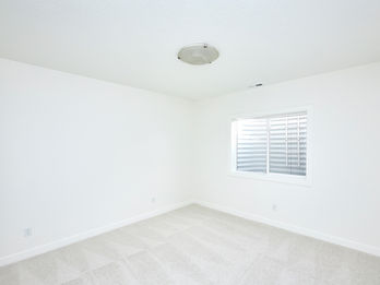 Empty white room with window and ceiling light