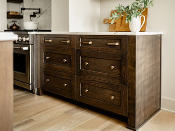 Dark wood kitchen island with drawers and plant
