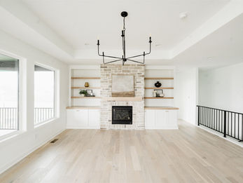 Modern living room with fireplace, built-in shelves, wood floor