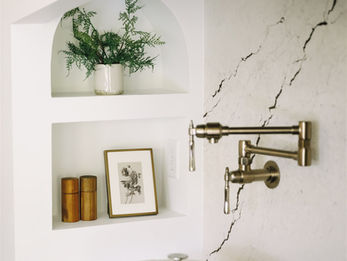 Modern kitchen with gas stove, pot filler, and marble backsplash