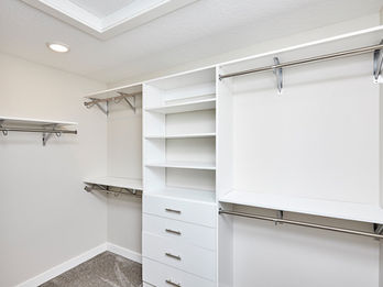 Modern white walk-in closet with shelving and rods