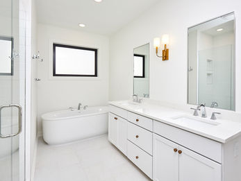 Bright white modern bathroom with tub and double vanity