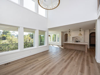 Great room with high ceilings, large windows, open to kitchen.