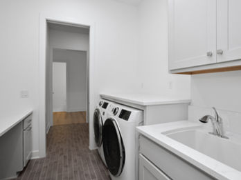 Modern laundry room with washer, dryer, and sink