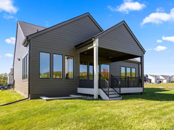 Modern house exterior with dark siding and covered patio
