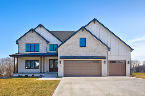 Modern house with light brick, white siding, and 2-car garage