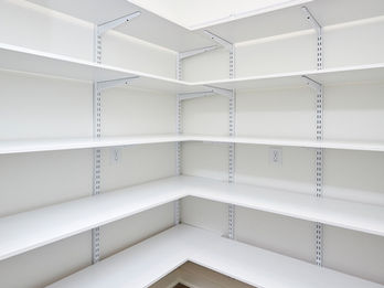Empty corner pantry with white shelves