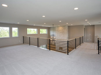 Spacious loft room with windows and black railings