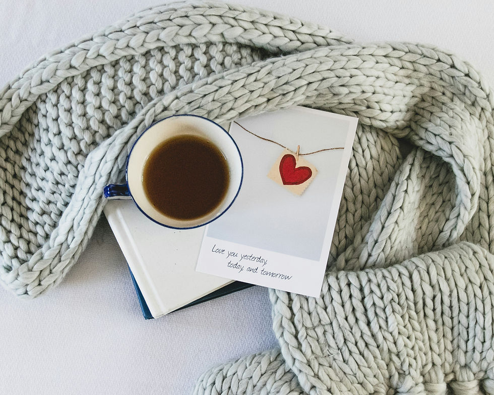 Knit blanket, cup of tea on a book, and a card with a red heart. Text reads "Love you yesterday, today, and tomorrow." Cozy vibe.