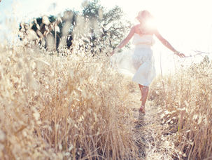 Woman walking freely through a sunlit field