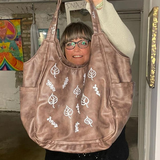  Large tote bag customized with white hand-painted symbols during a no-sew upcycling workshop.