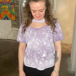 Participant wearing a light purple T-shirt with hand painted patterns and cutout cleavage 