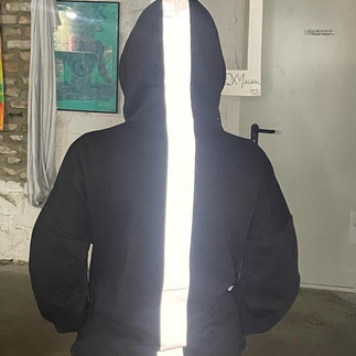 Black hoodie featuring a vertical iron-on reflective tape strip applied using no-sew customization techniques.