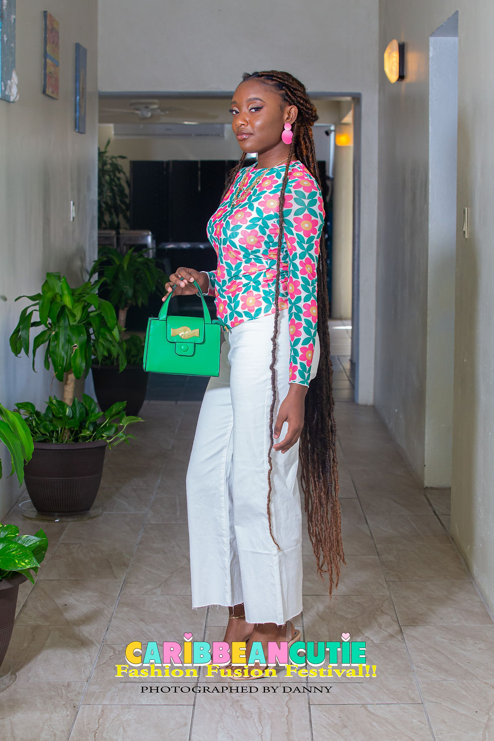 Model wearing a colorful floral top and white pants at the 2024 CaribbeanCutie Fashion Fusion Festival