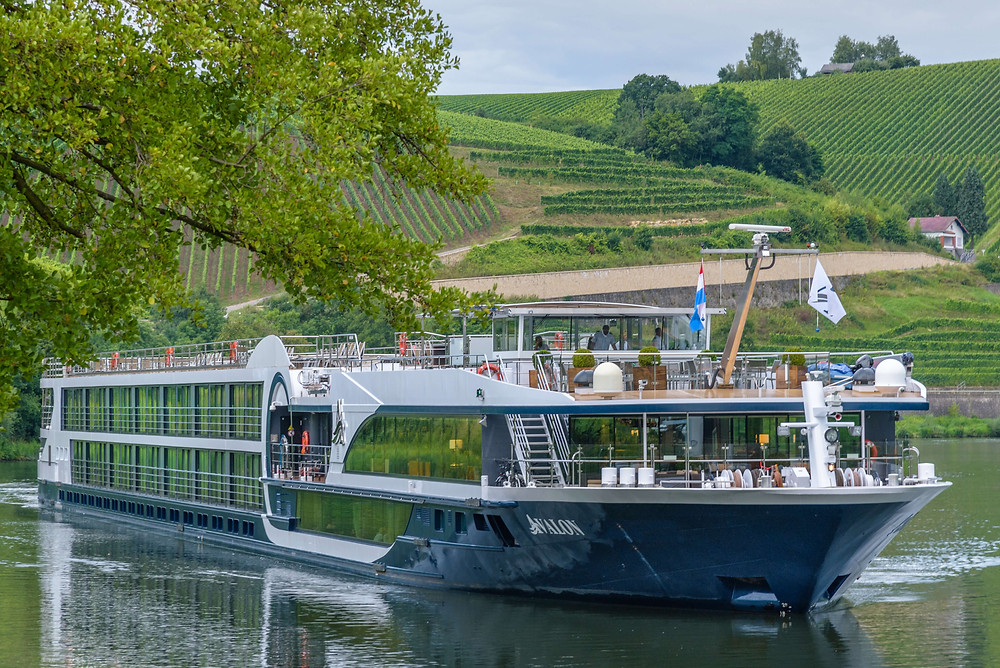 River cruise boat floats along countryside.