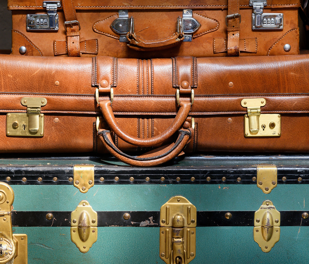 Packing for river cruise. Old luggage stacked on top of each other.