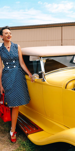 Sasha Nicole with a yellow vintage roadster at the Sauk Centre car show